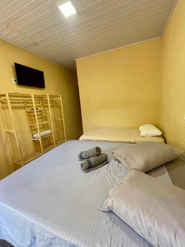 a bedroom with two beds and a flat screen tv at Mini Casa 5 in Itajaí