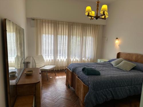 a bedroom with a bed and a desk and a table at Casa Tradicional del Barrio de la Estación in Tandil