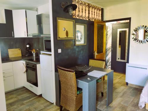 グレウー・レ・バンにあるStudio lumineux proche des thermes et du centre-village residence Parc Paradisの部屋にテーブルと椅子のあるキッチン