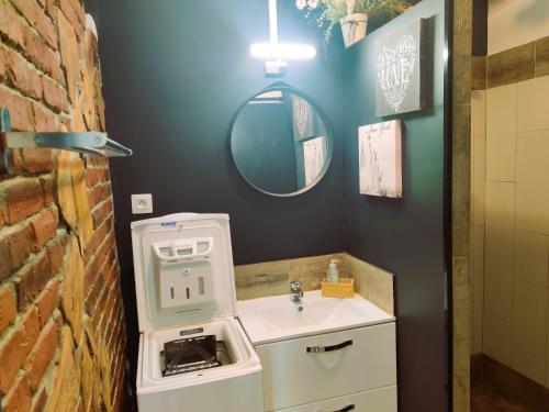 グレウー・レ・バンにあるStudio lumineux proche des thermes et du centre-village residence Parc Paradisのレンガの壁、洗面台付きのバスルーム