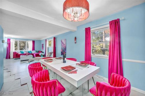 une salle à manger avec des chaises roses et une table blanche dans l'établissement Little Paris- In Affluent University HTS, à University Heights