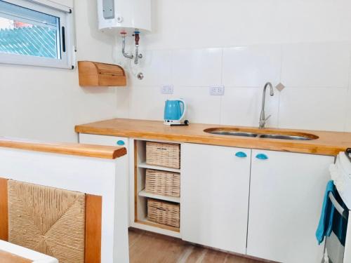 eine Küche mit weißen Schränken und einer Spüle in der Unterkunft Casa Blanca MH in Monte Hermoso