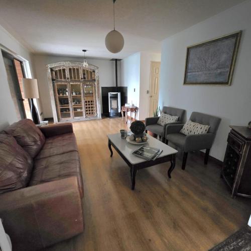 a living room with a couch and a coffee table at Acogedora Casa con Tinaja y Jacuzzi y RENT A CAR in Puerto Varas