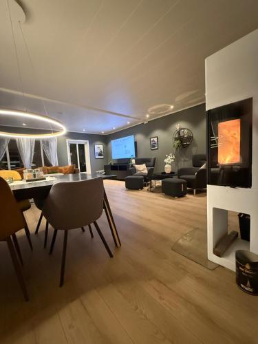 een woonkamer met een bank, een tafel en een tv bij KB Villa - Panoramic view in Sørvågen