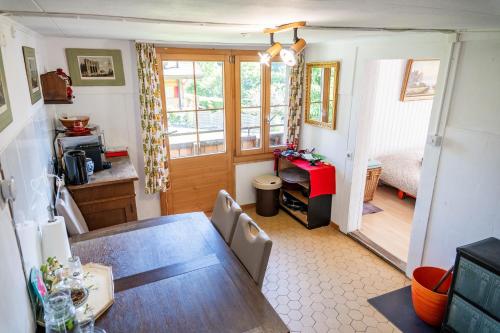 a dining room with a table and a bedroom at Romantic Alpine Farmhouse with Superview of Lake Near Interlaken in Sundlauenen