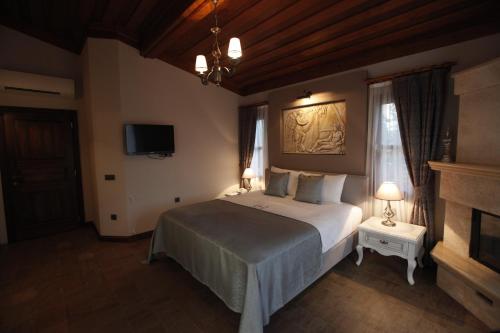 a bedroom with a large bed and a tv at Livia Hotel Ephesus in Selcuk