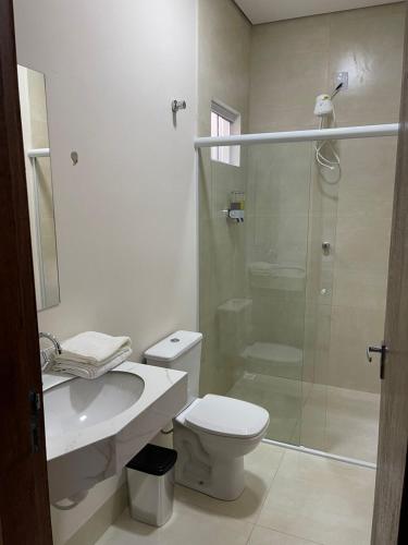 a bathroom with a shower and a toilet and a sink at Apartamento em Sinop 10 in Sinop