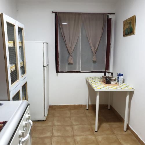 a small kitchen with a table and a refrigerator at Casita de Aldea in Sotrondio