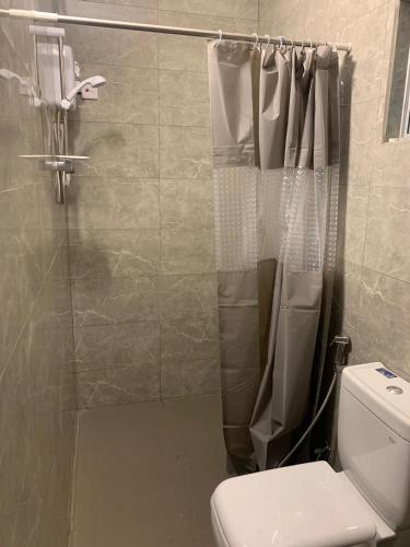 a bathroom with a shower and a toilet in it at Tenora Apartment in Kandy