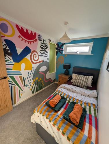 une chambre avec un lit et un tableau au mur dans l'établissement Stylish home, 3 bed with garden, Fast WiFi Parking, à Peterborough