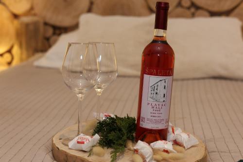 a bottle of wine and two wine glasses on a table at Rochowa Buźnica Apartament 1 in Zakopane