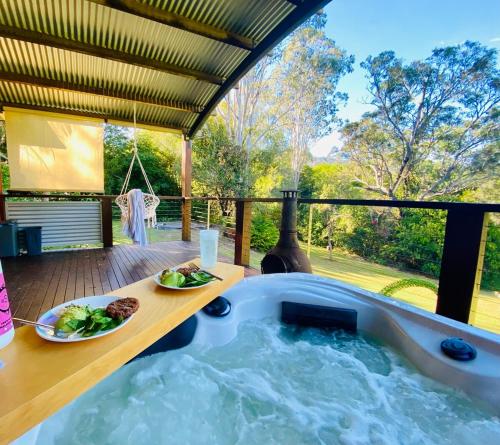 a jacuzzi tub with two plates of food in it at The Hinterland Spa & Moon Retreat in Boyland