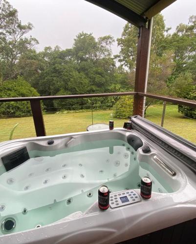 a jacuzzi tub on a porch with a view at The Hinterland Spa & Moon Retreat in Boyland