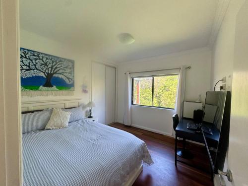 a bedroom with a bed and a desk and a window at The Hinterland Spa & Moon Retreat in Boyland