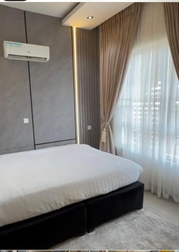 a bedroom with a bed and a large window at The Manor in Ikoyi