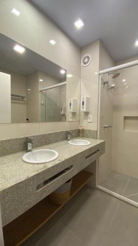 a bathroom with two sinks and a shower at Flat 102 Conforto e Charme in Canela