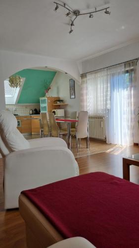 a living room with a white bed and a table at Apartman Bosco in Ravna Gora