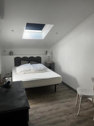 a bedroom with a large bed with a skylight at Séjour à Oléron Maison 3 étoiles in Saint-Denis-dʼOléron