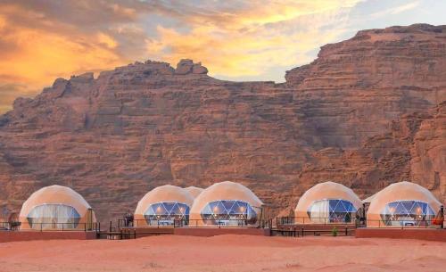Un cuadro de tres cúpulas frente a una montaña en وادي رم, en Wadi Rum