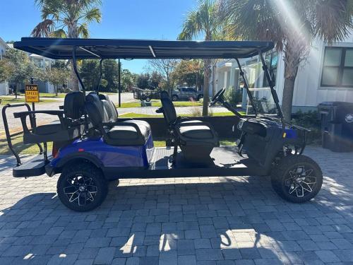 un carrello da golf con un tettuccio su una strada di Emerald Escape in Miramar Beach! Golf Cart, 4BR, 4BA, Sleeps 14, Pool, Beach a Destin