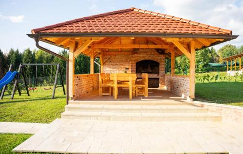 a wooden pavilion with a table and a playground at Awesome Home In Jamnica Pisarovinska With Sauna in Jamnica Pisarovinska