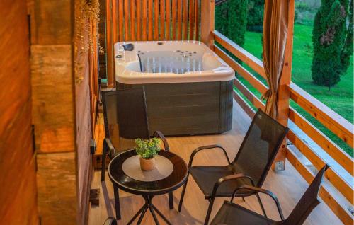 a bathroom with a tub and a table and chairs at Awesome Home In Jamnica Pisarovinska With Sauna in Jamnica Pisarovinska