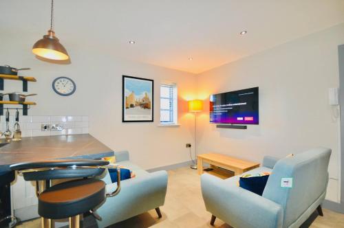 a kitchen and living room with a table and chairs at Luxury Two Bed Suite - Walk to Trentham Gardens! in Stoke on Trent