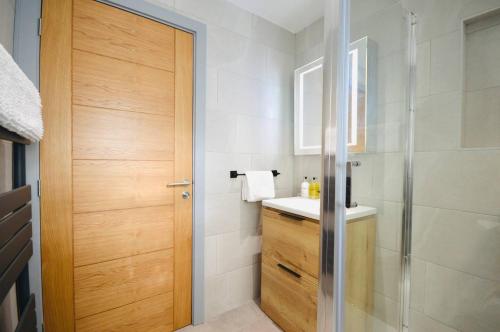 a bathroom with a shower and a wooden door at Luxury Two Bed Suite - Walk To Trentham Gardens! in Stoke on Trent