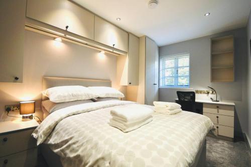 a bedroom with a large bed with towels on it at Luxury Two Bed Suite - Walk To Trentham Gardens! in Stoke on Trent