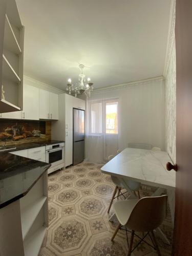 Kuchyň nebo kuchyňský kout v ubytování Уютная 2-комнатная квартира на Кошкарбаева