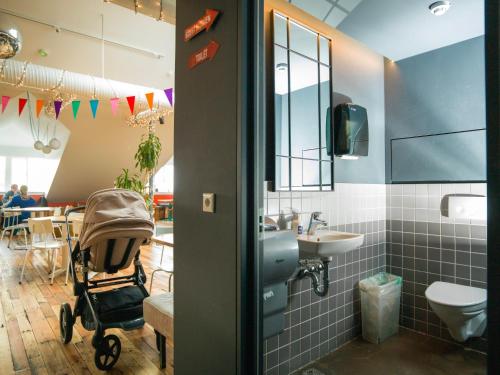 レイキャビクにあるLoft - HI Eco Hostelのベビーカーと洗面台を備えたバスルーム
