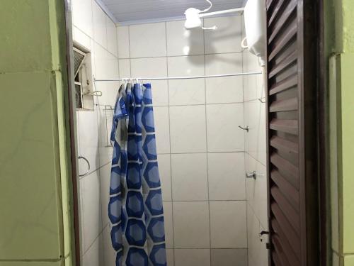 una doccia con una tenda da doccia blu in un bagno di Casa para Estadia a Foz do Iguaçu
