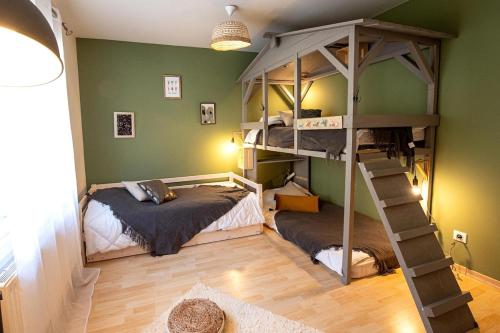 two bunk beds in a room with green walls at Gîte Le repaire du faon-4 étoiles-12 pers-filet mezzanine-lit cabane in Plainfaing