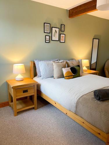 ein Schlafzimmer mit einem Bett, zwei Tischen und einer Lampe in der Unterkunft Hadrians Retreat, Cosy 1 Bed Flat - near M6 Jct45, A75, Gretna & Carlisle in Longtown