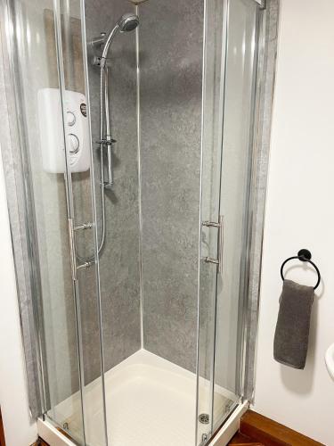 eine Dusche mit Glastür im Badezimmer in der Unterkunft Hadrians Retreat, Cosy 1 Bed Flat - near M6 Jct45, A75, Gretna & Carlisle in Longtown