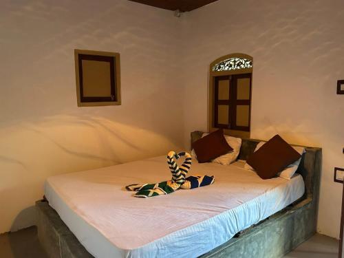 a stuffed animal sitting on a bed in a room at Cabana Unawatuna in Unawatuna