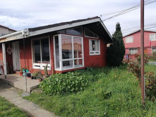 a red house with a window on the side of it at Habitación privada en Puerto Varas in Puerto Varas