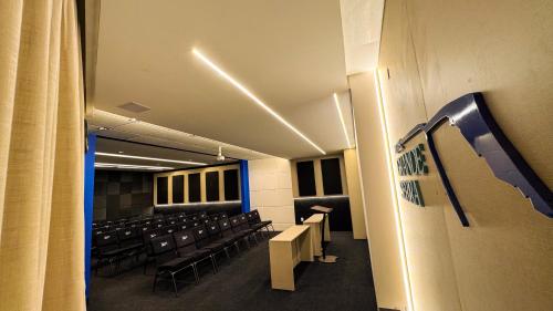 een kamer met rijen stoelen, tafels en gordijnen bij Hotel Grande Serra in Trindade