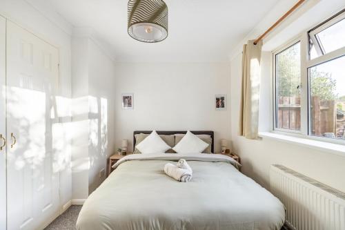 ein Schlafzimmer mit einem Bett, auf dem ein Stofftier liegt in der Unterkunft Cosy 2-Bed Maisonette in Ashford in Kennington
