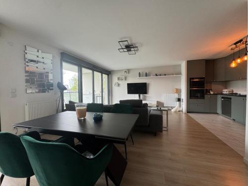 ein Wohnzimmer mit einem Tisch und grünen Stühlen in der Unterkunft Quiet and Spacious 2BR And Salon Terrasse Parking in Saint-Denis