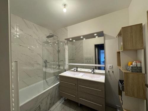 ein Badezimmer mit Dusche, Waschbecken und Badewanne in der Unterkunft Quiet and Spacious 2BR And Salon Terrasse Parking in Saint-Denis