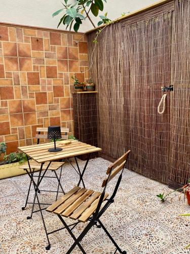 a patio with a table and a bench and a shower at La Vega Rooms in Huelva