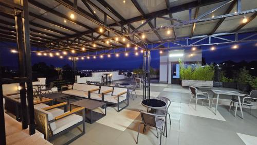 een dakterras met tafels, stoelen en verlichting bij The White Residence Kigali in Kigali