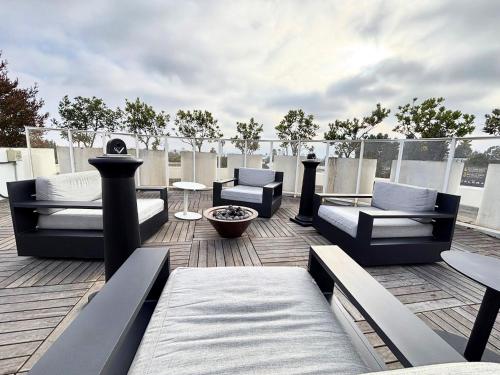 un patio avec des canapés et des chaises sur un toit dans l'établissement Melrose Luxe Retreat near The Grove, à Los Angeles