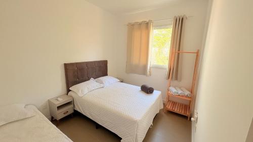 a small bedroom with a bed and a window at palmas beach in Governador Celso Ramos