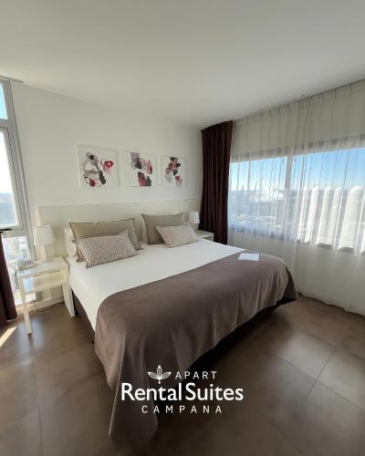 a bedroom with a large bed in a room with windows at RENTAL SUITES CAMPANA in Campana