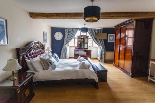 a bedroom with a large bed and a clock on the wall at Spacious 5 Family Rooms House By Shropshire Escapes Short Lets & Serviced Accommodation Shrewsbury With Free WiFi in Shrewsbury