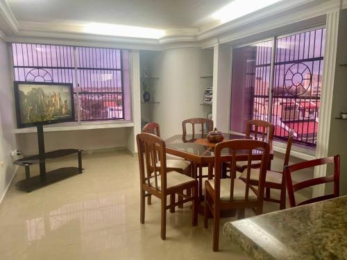 a dining room with a table and chairs and a tv at Comfortable apartment, excellent location in Maracaibo