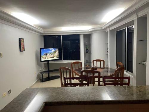 a dining room with a table and chairs and a television at Comfortable apartment, excellent location in Maracaibo