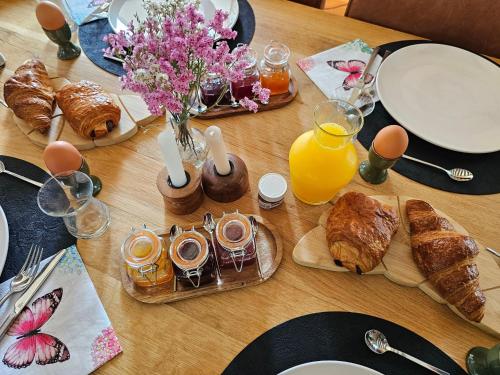 une table avec des croissants, du jus d'orange et des œufs dans l'établissement Le Cocon - Domaine du Vertendre, à Saint-Yrieix-la-Perche